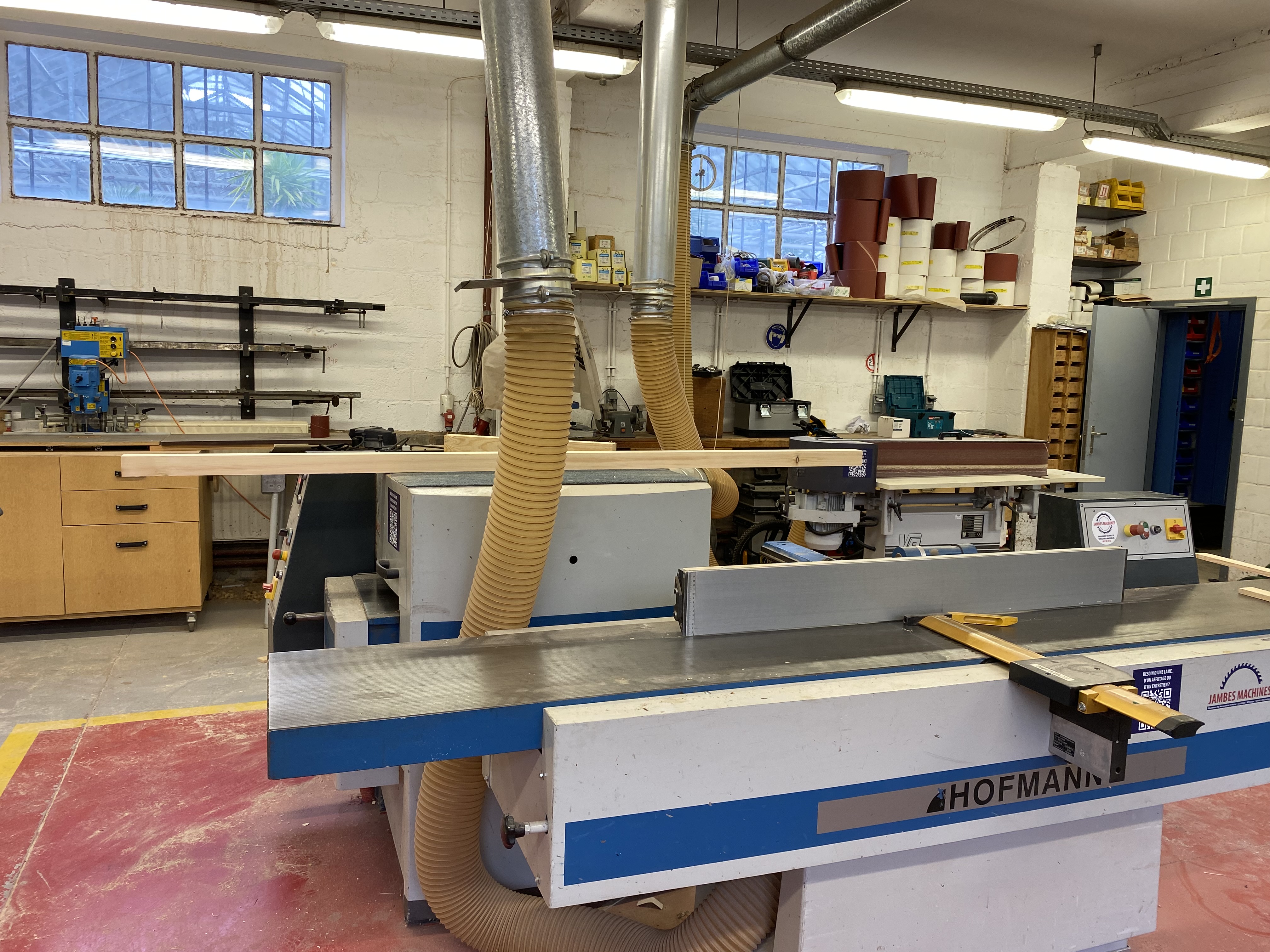 Twee grote zaagtafels en andere werktafels in het atelier van de schrijnwerkers van Leefmilieu Brussel.