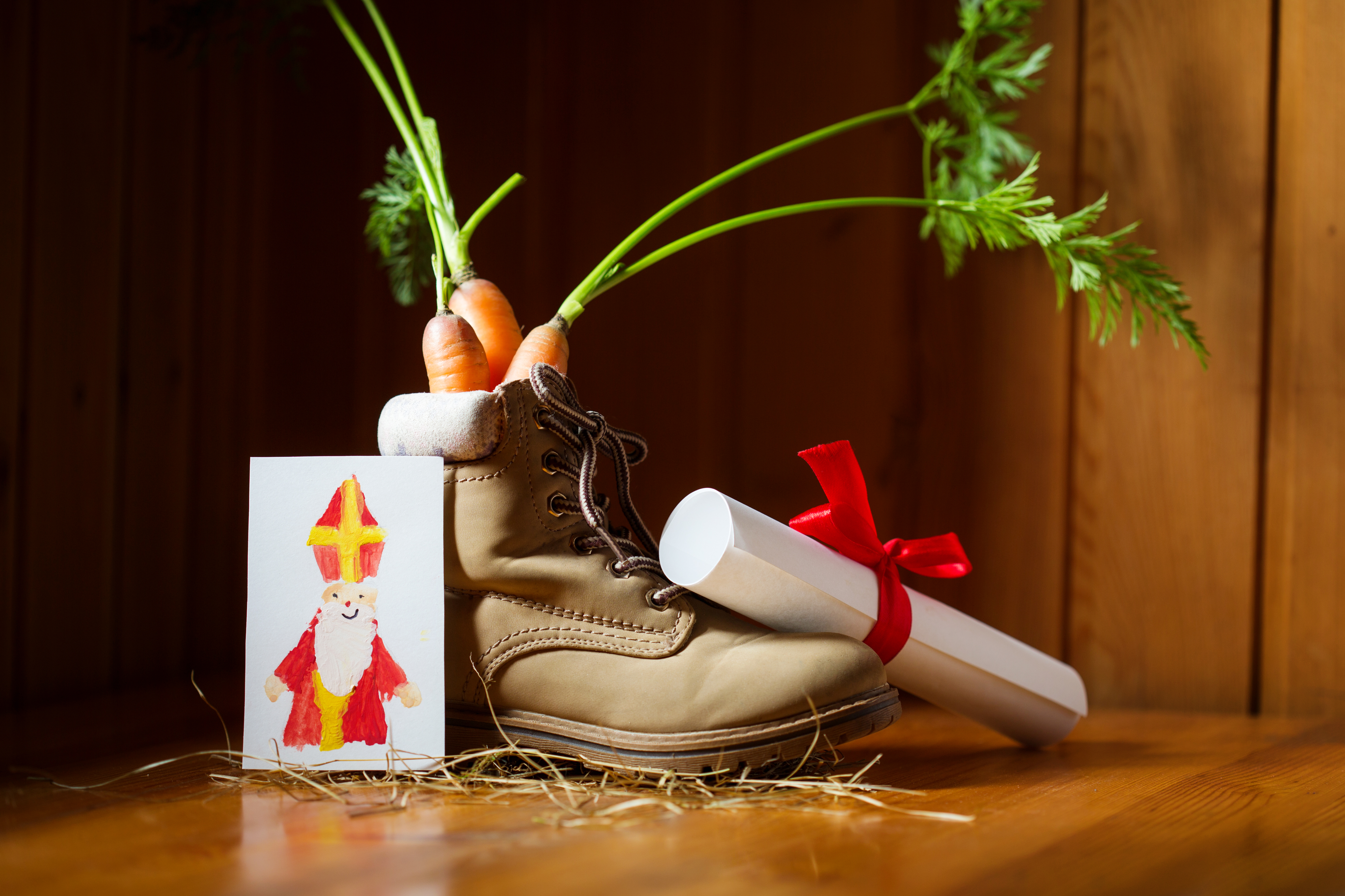 Kinderschoen gevuld met 3 wortels en omringd door een brief en een tekening voor Sinterklaas.