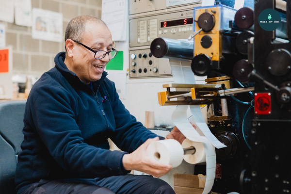 Un homme avec un rouleau de papier dans un atelier