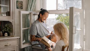 Un homme et une femme lisent devant une fenêtre ouverte