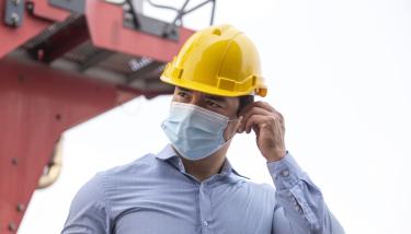 Homme avec casque et masque de protection sur un chantier