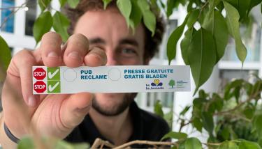 Personne tenant un autocollant stop pub